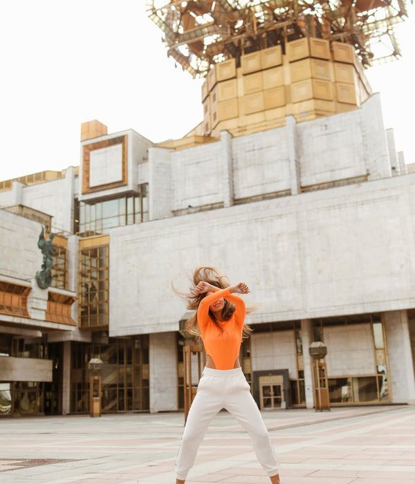 Woman feeling energetic and vibrant in a bright, open space.
